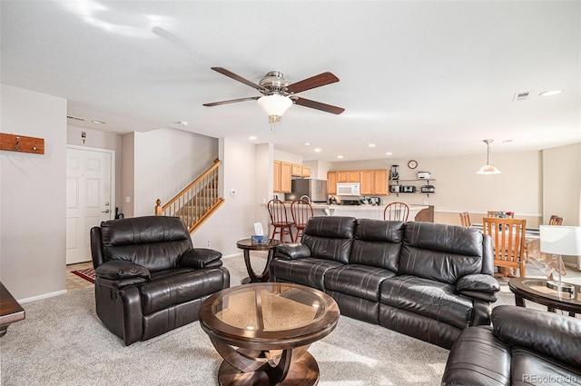 living area featuring stairway, recessed lighting, visible vents, and light colored carpet