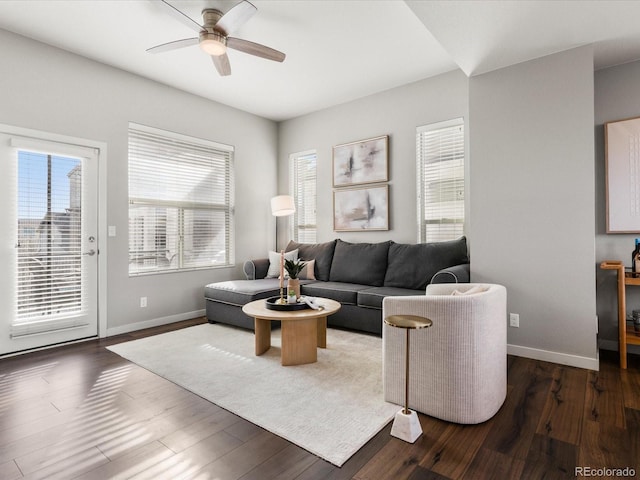 living room featuring wood finished floors, baseboards, and ceiling fan