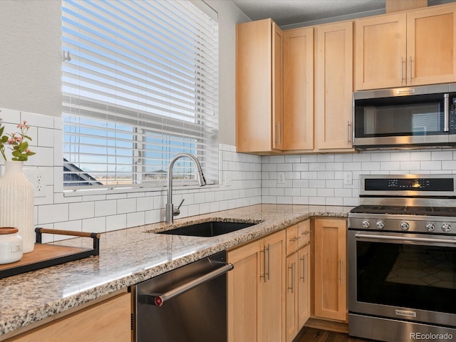 kitchen featuring a sink, decorative backsplash, light brown cabinetry, and stainless steel appliances