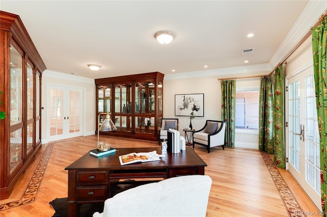 home office with visible vents, baseboards, light wood-style floors, french doors, and crown molding