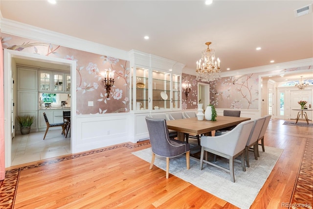 dining area featuring wallpapered walls, visible vents, a notable chandelier, and a wainscoted wall