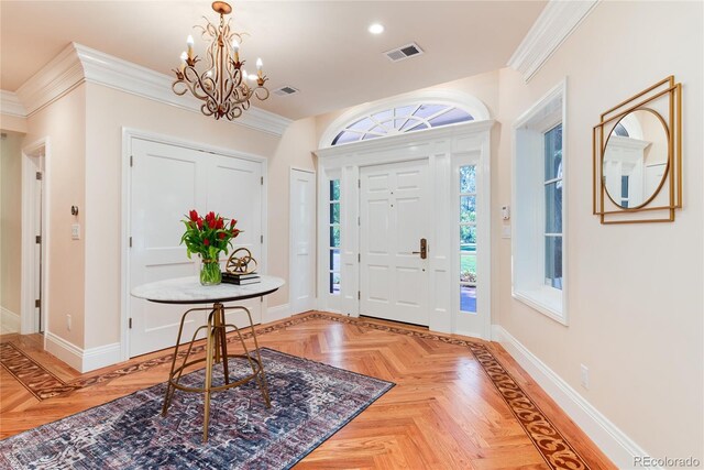 foyer with a chandelier, ornamental molding, visible vents, and baseboards