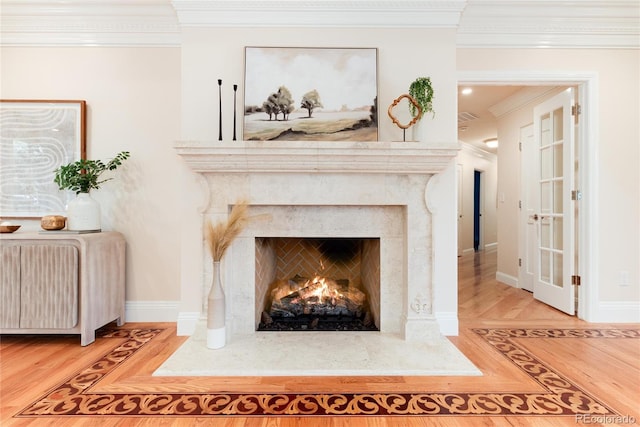 room details with ornamental molding, a fireplace, wood finished floors, and baseboards