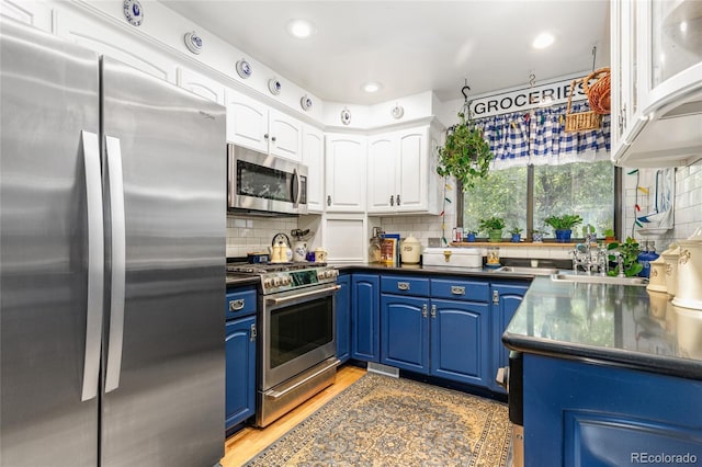 2685 S Dayton Way Unit 253, Denver, CO 80231 - kitchen featuring appliances with stainless steel finishes, blue cabinetry, dark countertops, white cabinetry, and recessed lighting