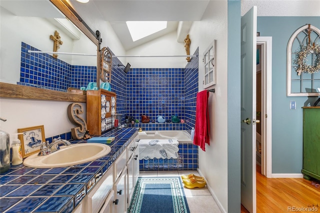 2685 S Dayton Way Unit 253, Denver, CO 80231 - full bath featuring a skylight, vanity, tiled shower / bath, and vaulted ceiling