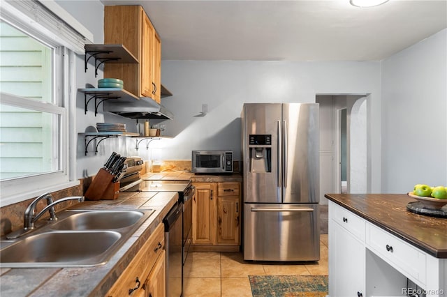 60 Vrain St, Denver, CO 80219 - kitchen featuring appliances with stainless steel finishes, open shelves, light tile patterned floors, tile countertops, and brown cabinets
