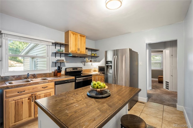 60 Vrain St, Denver, CO 80219 - kitchen with stainless steel appliances, open shelves, under cabinet range hood, light tile patterned flooring, and butcher block countertops