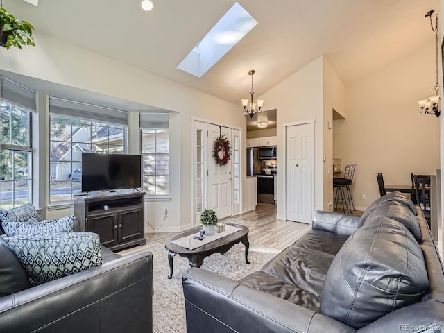 living room featuring an inviting chandelier, lofted ceiling, and light wood-type flooring