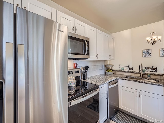 kitchen with backsplash, sink, dark stone countertops, white cabinetry, and stainless steel appliances