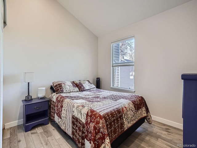 bedroom with vaulted ceiling and light hardwood / wood-style flooring