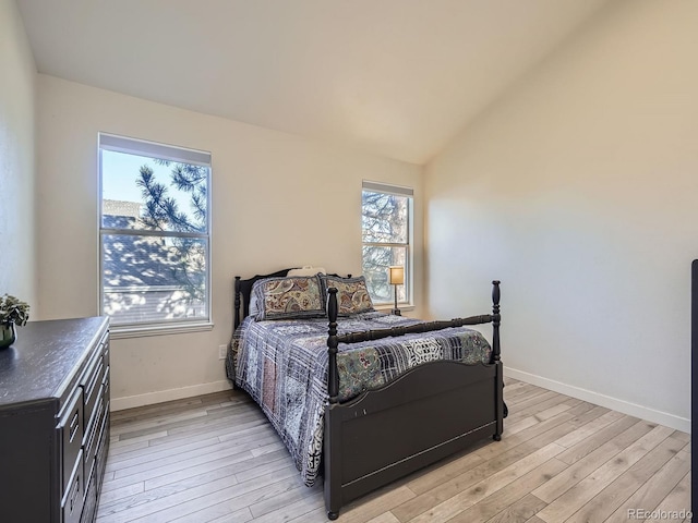 bedroom with vaulted ceiling and light wood-type flooring