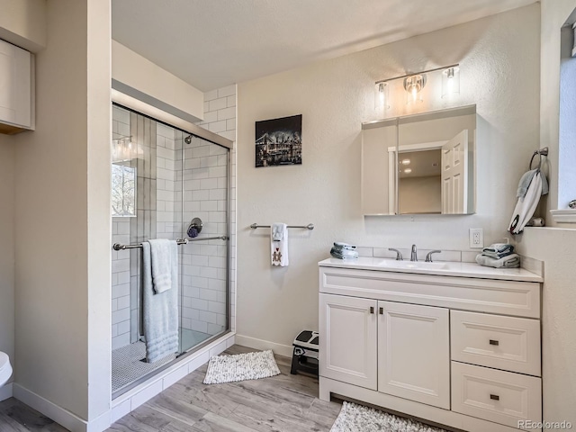 bathroom featuring hardwood / wood-style floors, vanity, and a shower with shower door