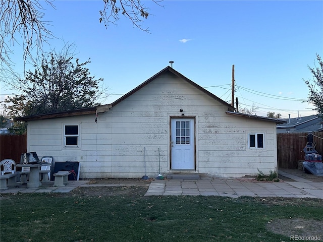 rear view of property with a lawn and a patio