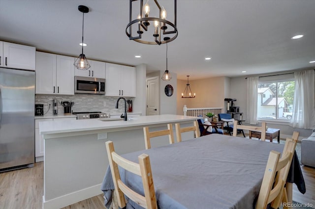 5945 W 86th Ave, Arvada, CO 80003 - dining area featuring a chandelier, light wood-type flooring, and recessed lighting