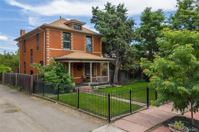 256 Bannock St, Denver, CO 80223 - american foursquare style home with covered porch, brick siding, a fenced front yard, and a chimney