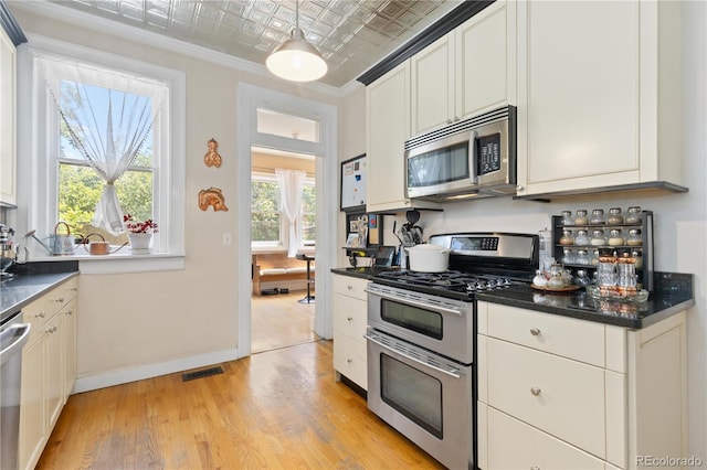 256 Bannock St, Denver, CO 80223 - kitchen featuring stainless steel appliances, an ornate ceiling, dark countertops, light wood-style floors, and crown molding
