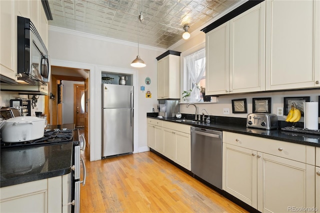 256 Bannock St, Denver, CO 80223 - kitchen featuring stainless steel appliances, an ornate ceiling, ornamental molding, dark countertops, and light wood-style floors