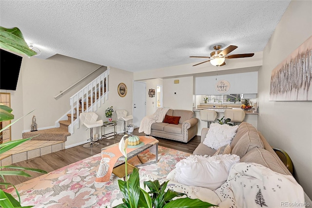 living room with a textured ceiling, dark hardwood / wood-style floors, and ceiling fan