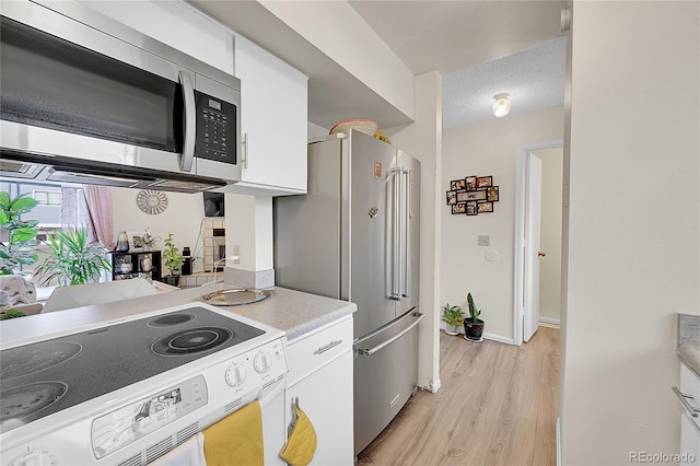 kitchen featuring white cabinets, light hardwood / wood-style floors, a textured ceiling, and appliances with stainless steel finishes