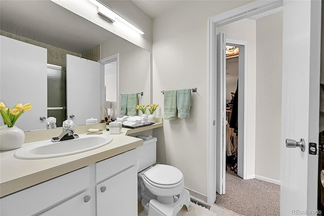 bathroom featuring vanity, an enclosed shower, and toilet