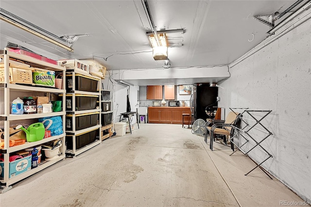 garage with stainless steel fridge and sink