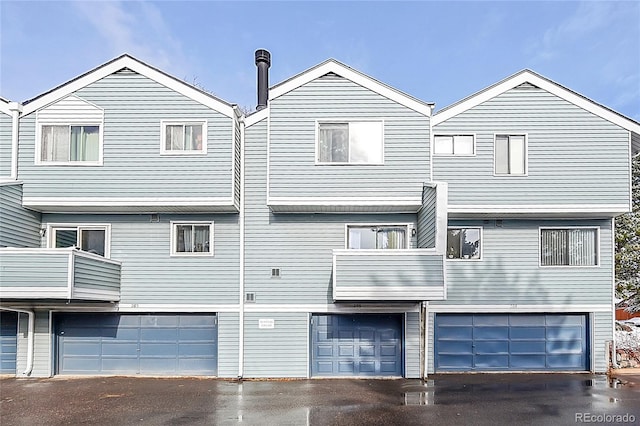 back of property featuring a garage and a balcony