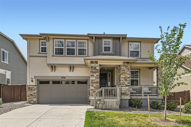 14551 Hudson St, Thornton, CO 80602 - view of front of home with driveway, fence, a porch, stone siding, and a garage