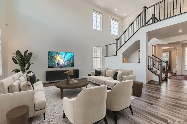 14551 Hudson St, Thornton, CO 80602 - living area featuring stairway, healthy amount of natural light, wood finished floors, a towering ceiling, and recessed lighting