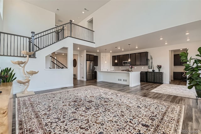 14551 Hudson St, Thornton, CO 80602 - living room with dark wood-style floors, stairs, a high ceiling, and recessed lighting