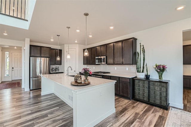 14551 Hudson St, Thornton, CO 80602 - kitchen with appliances with stainless steel finishes, dark brown cabinets, light wood-style flooring, light countertops, and recessed lighting