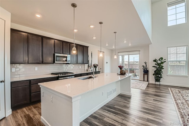 14551 Hudson St, Thornton, CO 80602 - kitchen featuring stainless steel microwave, stove, dark brown cabinets, dark wood-style flooring, and recessed lighting