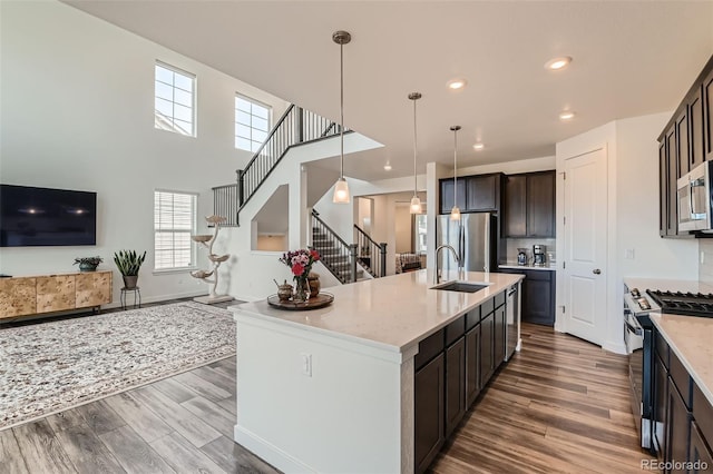 14551 Hudson St, Thornton, CO 80602 - kitchen with appliances with stainless steel finishes, wood finished floors, pendant lighting, a center island with sink, and recessed lighting