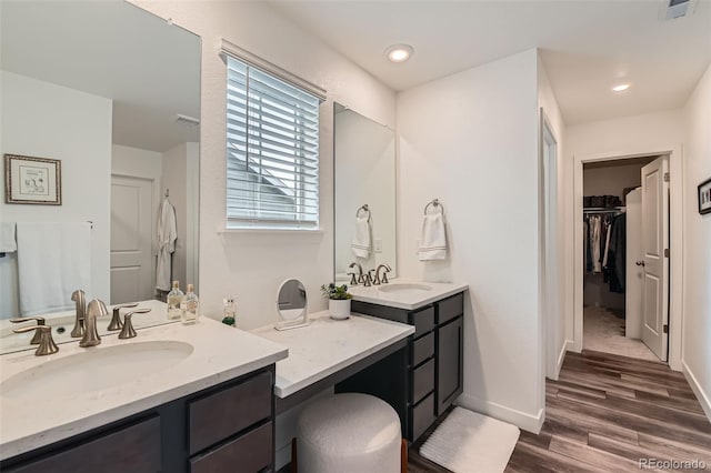 14551 Hudson St, Thornton, CO 80602 - full bathroom with two vanities, a walk in closet, and wood finished floors