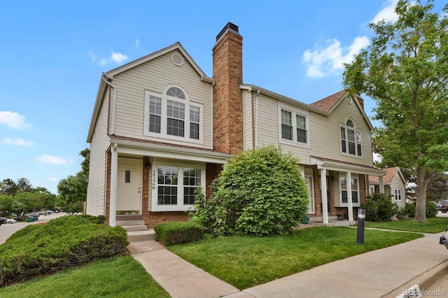 14396 E Temple Pl Unit D, Aurora, CO 80015 - view of front of home with a chimney, a front lawn, and brick siding