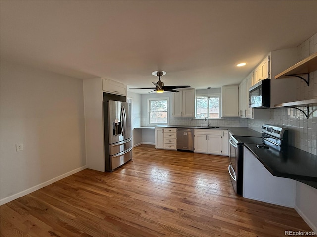 4670 Independence St, Wheat Ridge, CO 80033 - kitchen featuring appliances with stainless steel finishes, a sink, tasteful backsplash, dark countertops, and dark wood-style floors