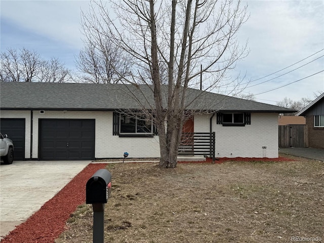 4670 Independence St, Wheat Ridge, CO 80033 - view of front of house with brick siding, concrete driveway, an attached garage, and a shingled roof