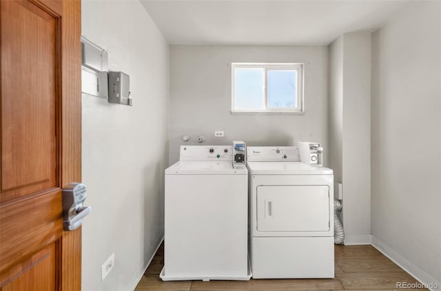 clothes washing area with wood-type flooring and washing machine and dryer