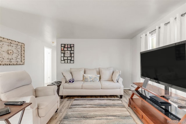 living room with hardwood / wood-style floors and a baseboard heating unit