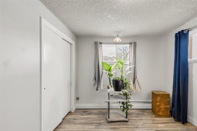 entryway with a textured ceiling and light hardwood / wood-style flooring