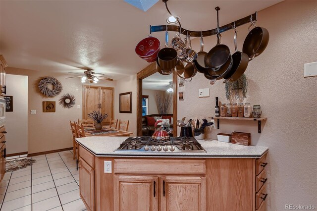 5900 W 62nd Ave, Arvada, CO 80003 - kitchen featuring stainless steel gas cooktop, ceiling fan, light tile patterned flooring, light countertops, and a textured wall