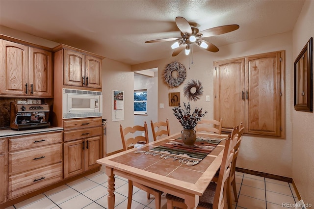 5900 W 62nd Ave, Arvada, CO 80003 - dining room featuring light tile patterned floors, a ceiling fan, and a textured ceiling