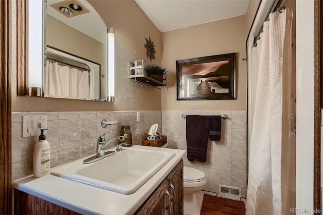 5900 W 62nd Ave, Arvada, CO 80003 - full bathroom featuring tile walls, vanity, curtained shower, wood finished floors, and a wainscoted wall