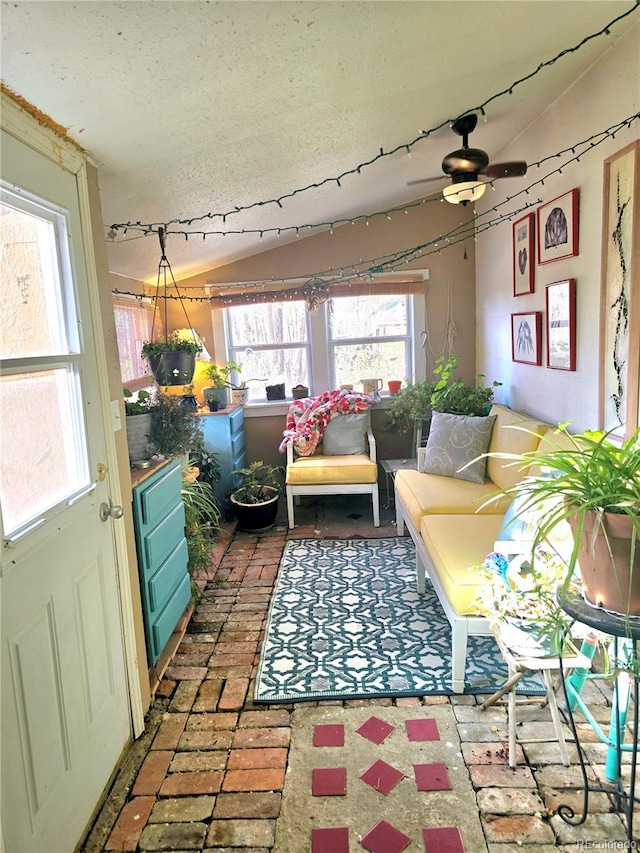 sunroom featuring lofted ceiling and ceiling fan