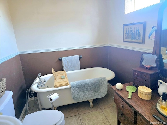 bathroom featuring tile patterned flooring, toilet, and a bathtub