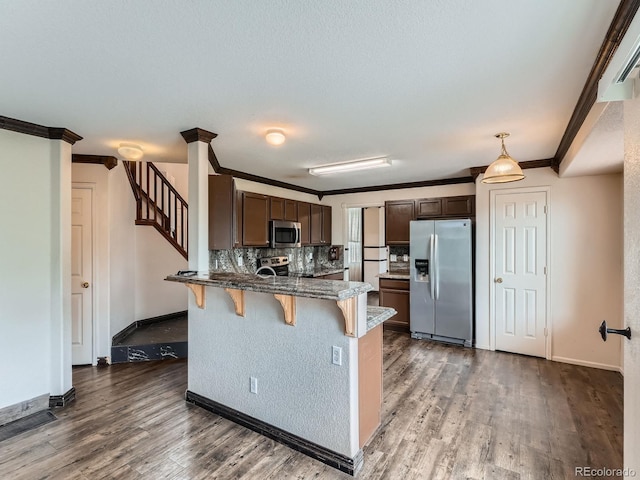 5553 Jasper St, Denver, CO 80239 - kitchen featuring stainless steel appliances, a peninsula, a breakfast bar area, ornamental molding, and backsplash