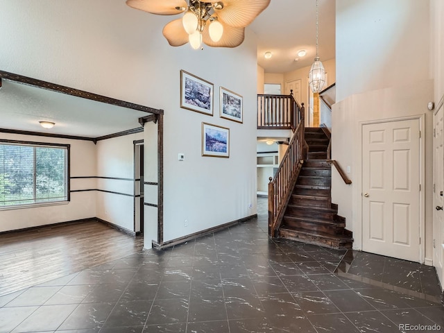 5553 Jasper St, Denver, CO 80239 - stairs featuring ceiling fan, a towering ceiling, and tile patterned floors