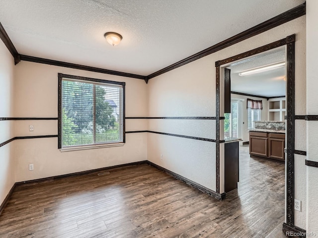5553 Jasper St, Denver, CO 80239 - empty room featuring ornamental molding, a textured ceiling, wood finished floors, healthy amount of natural light, and a textured wall