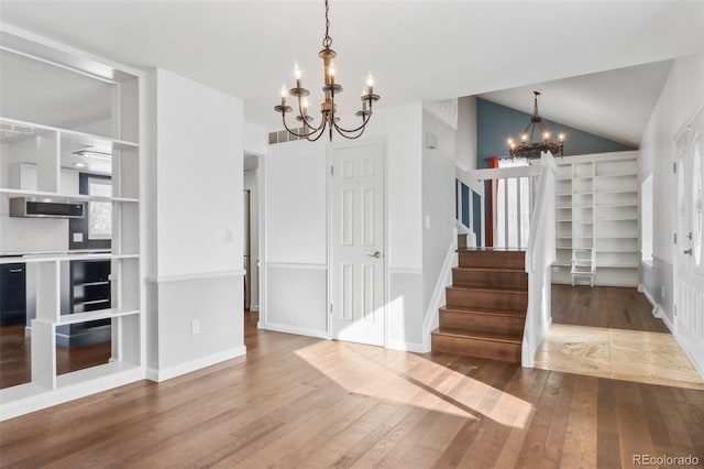 interior space featuring hardwood / wood-style floors, lofted ceiling, and a chandelier