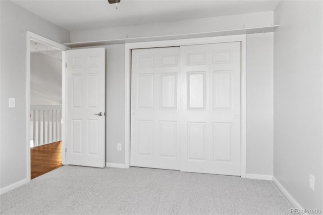 unfurnished bedroom with light carpet and a closet