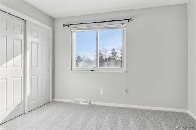 unfurnished bedroom with light carpet and a closet